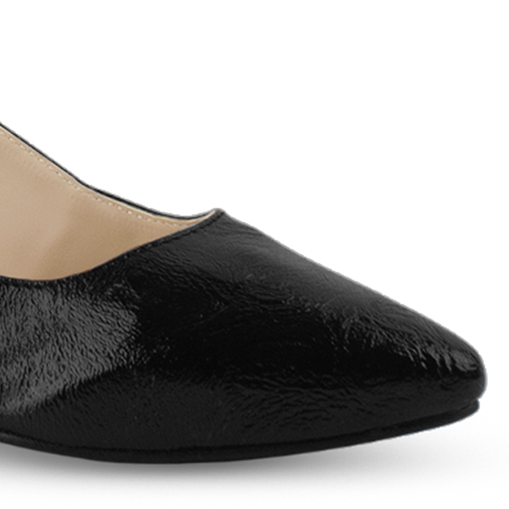 Vista a detalle de punta fina cerrada en zapatilla negra para mujer con correa ajustable y tacón bajo de 5cm