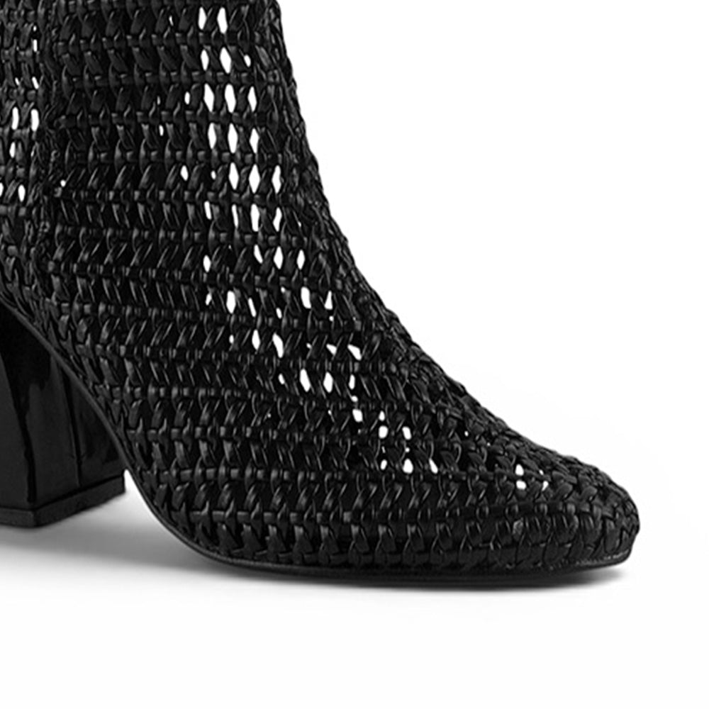 detalle del material sintético en las botas negras tejidas de dama con tacón medio 8 cm