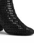 detalle del material sintético en las botas negras tejidas de dama con tacón medio 8 cm