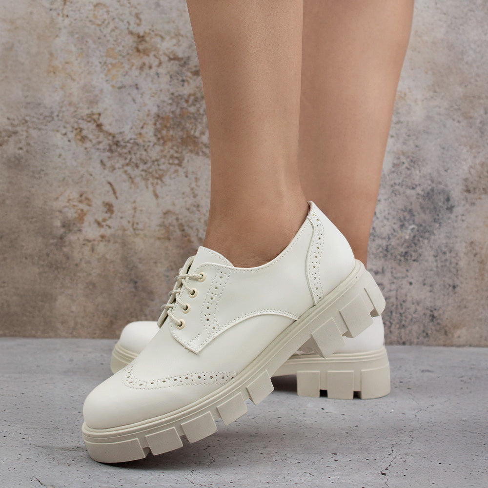 Mocasines beige chunky con suela dentada tipo track, cordones para mayor ajuste y detalles clásicos 