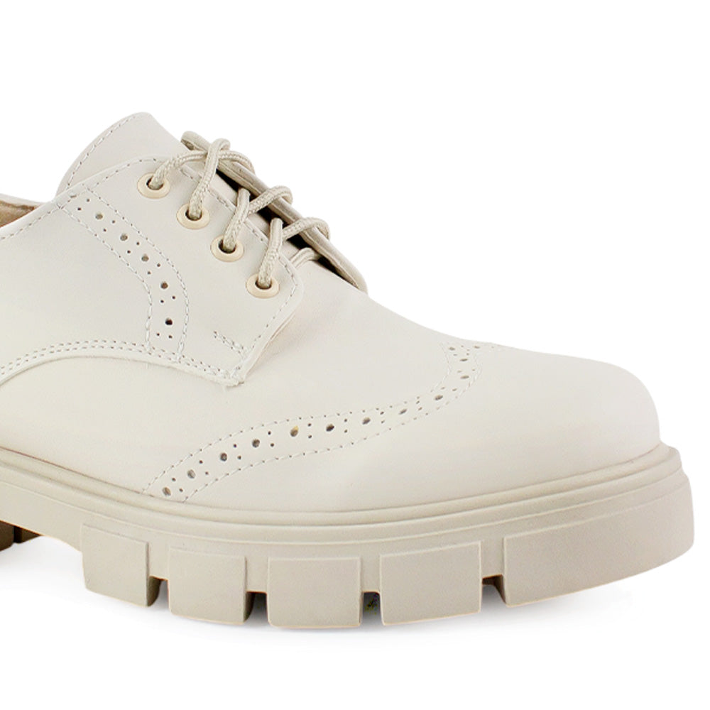 Detalle del material cabra sintético en el mocasín beige para dama con cordones funcionales y suela dentada tipo track 