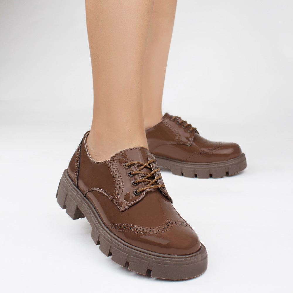 Mocasines cafés chunky de charol con suela dentada tipo track, cordones para mayor ajuste y detalles clásicos 
