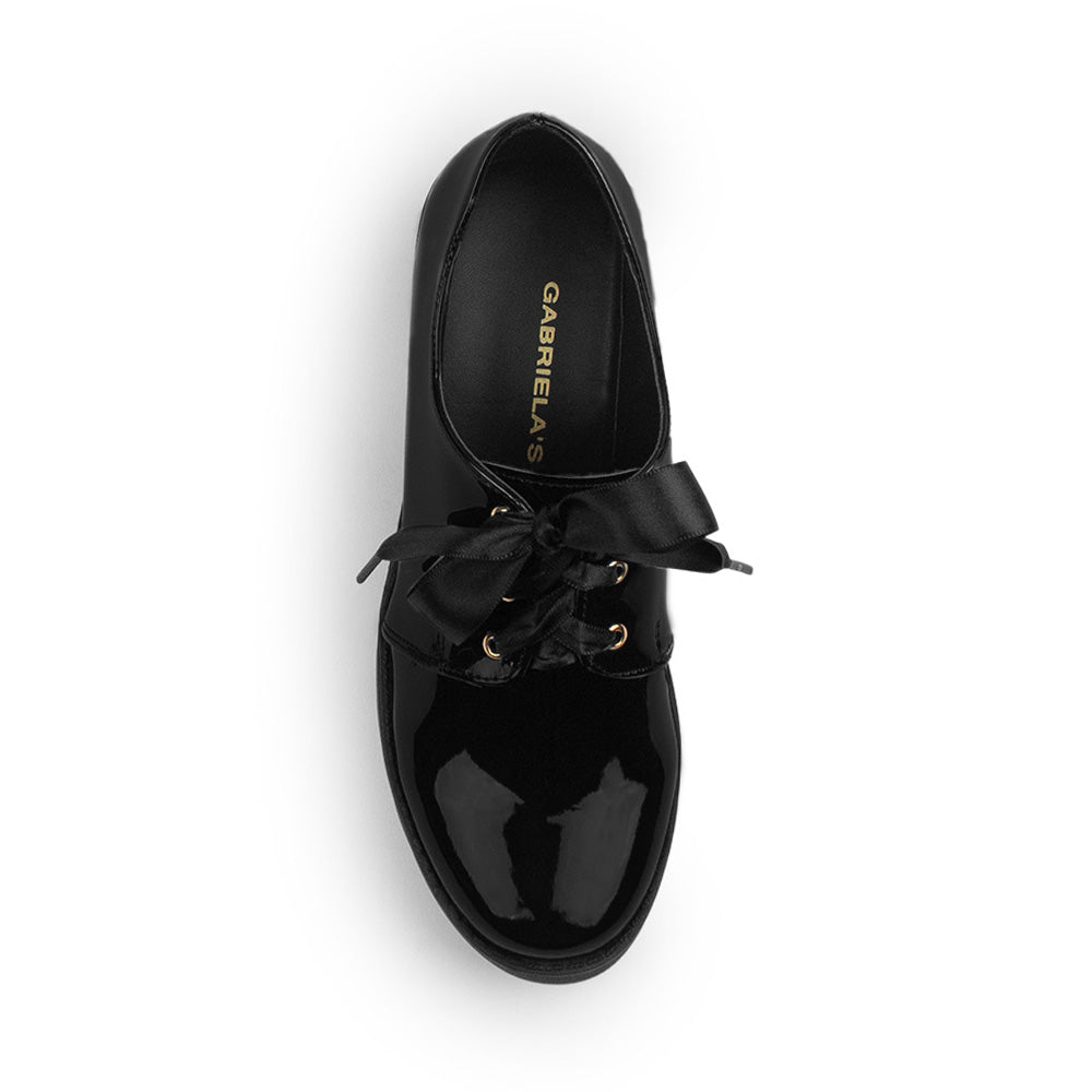 Vista superior del mocasín negro de charol tipo chunky con listones, plataforma y tacón bajo 5m para dama