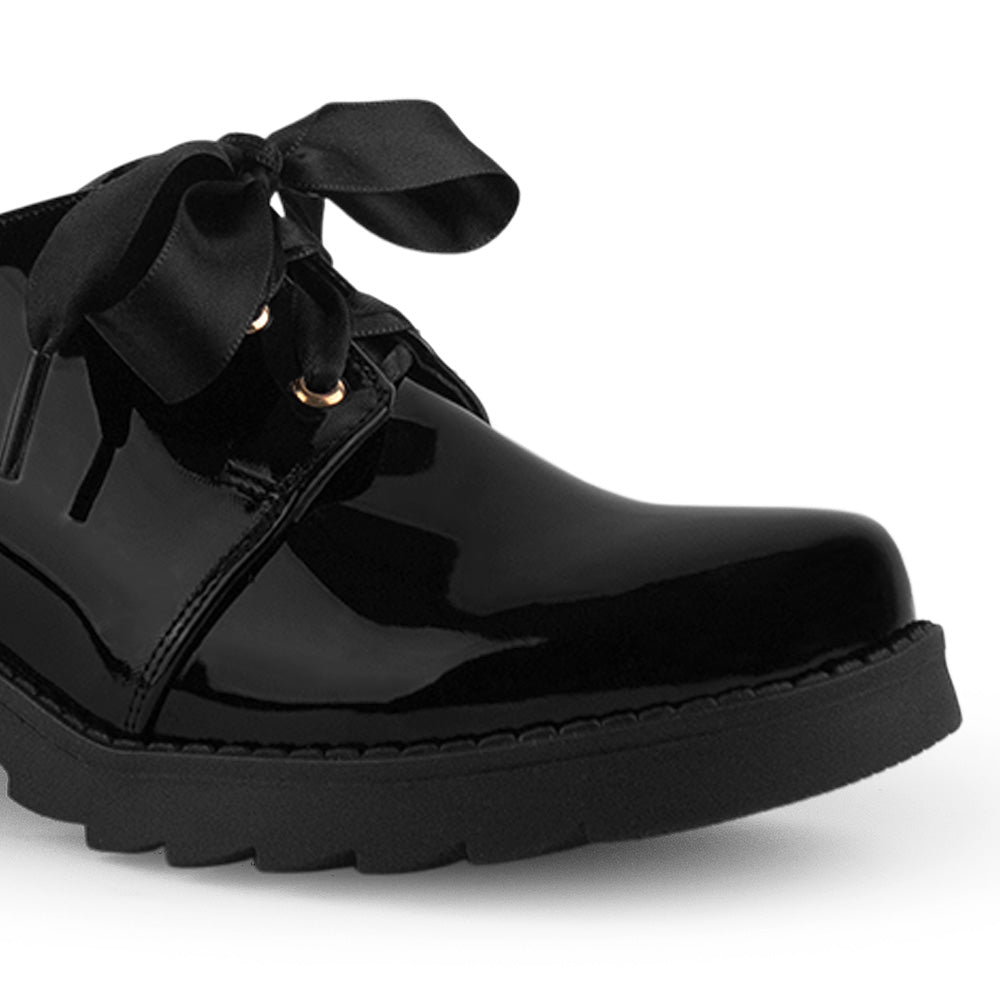Detalle del material charol en el mocasín negro tipo chunky para dama con listones de plataforma y tacón bajo 5cm 