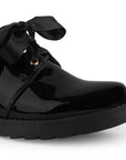 Detalle del material charol en el mocasín negro tipo chunky para dama con listones de plataforma y tacón bajo 5cm 