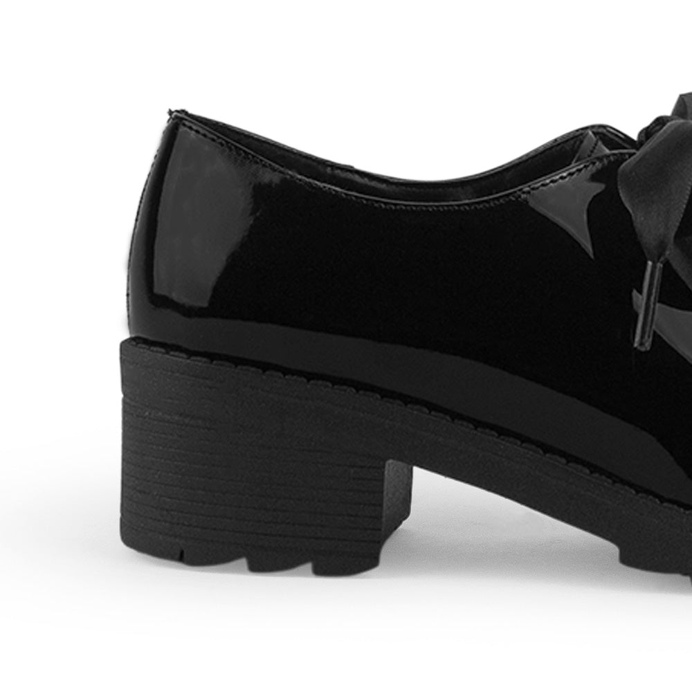 Vista trasera del mocasín negro para dama de charol con listones tacón bajo tamaño grueso 5cm y plataforma