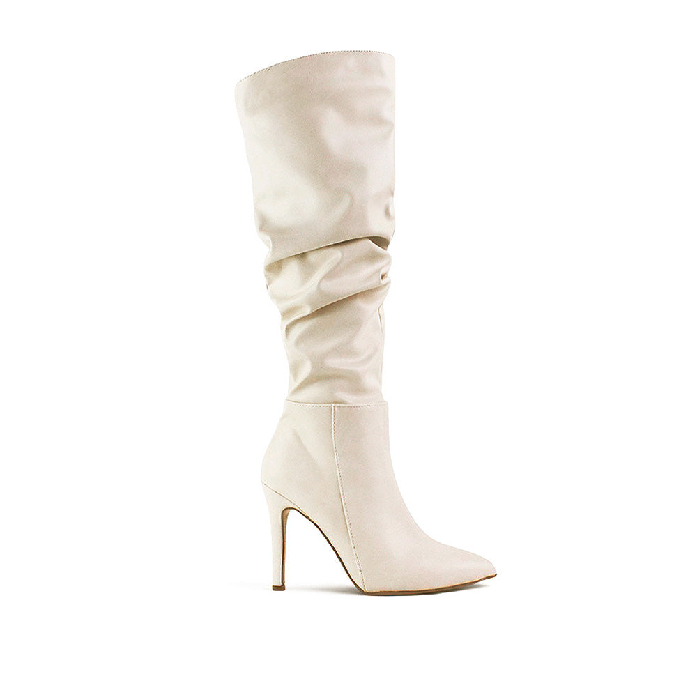 vista lateral de botas plisadas beige para dama con tacón delgado y punta estilizada 