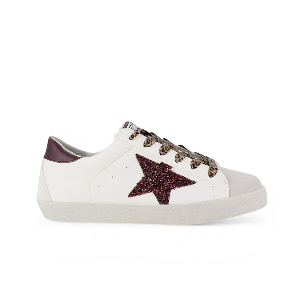 Vista lateral del tenis beige con estrella lateral de glitter y suela baja 2 cm para dama