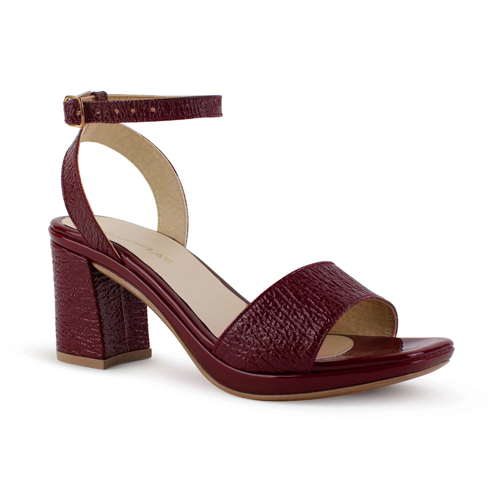 Vista diagonal de zapatillas vino para mujer con pulsera ajustable al tobillo y tacón ancho medio de 8cm