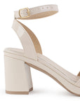 Vista trasera de tacón ancho medio de 8cm en zapatilla beige de diseño descubierto para mujer con pulsera ajustable y punta cuadrada