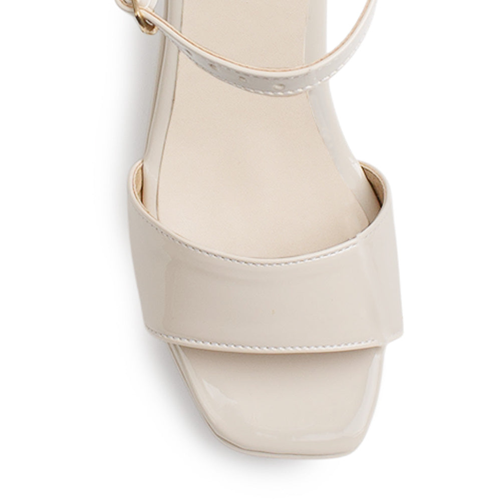 Vista de material charol en zapatilla de diseño descubierto para mujer con pulsera ajustable y tacón medio de 8cm en color beige 