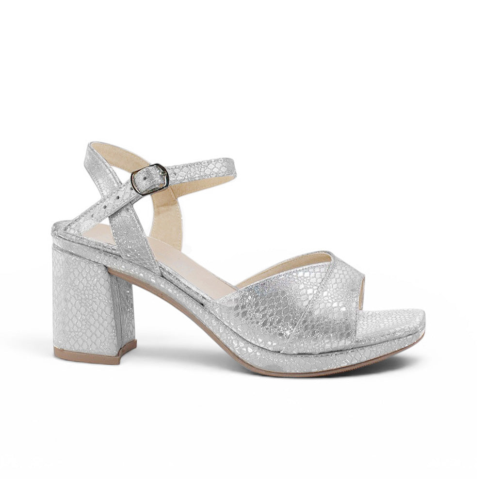 Vista lateral de zapatilla plateada para mujer de diseño descubierto con tacón ancho de 8cm y pulsera ajustable