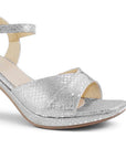 Vista a detalle de zapatilla plateada para mujer de diseño descubierto con pulsera ajustable y tacón ancho de 8cm