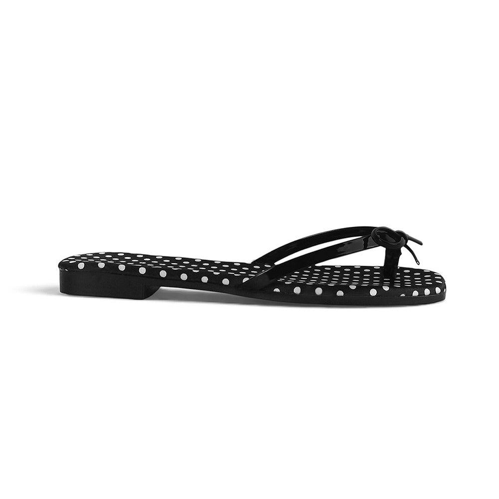 Vista lateral en sandalia negra para dama con moño y suela con diseño de lunares 