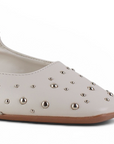 detalle del material sintético en balerinas beige con pulsera ajustable y estoperoles