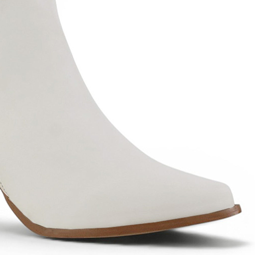 Detalle del material sintético del botín beige para dama con punta fina, herraje metálico y tacón medio 7cm