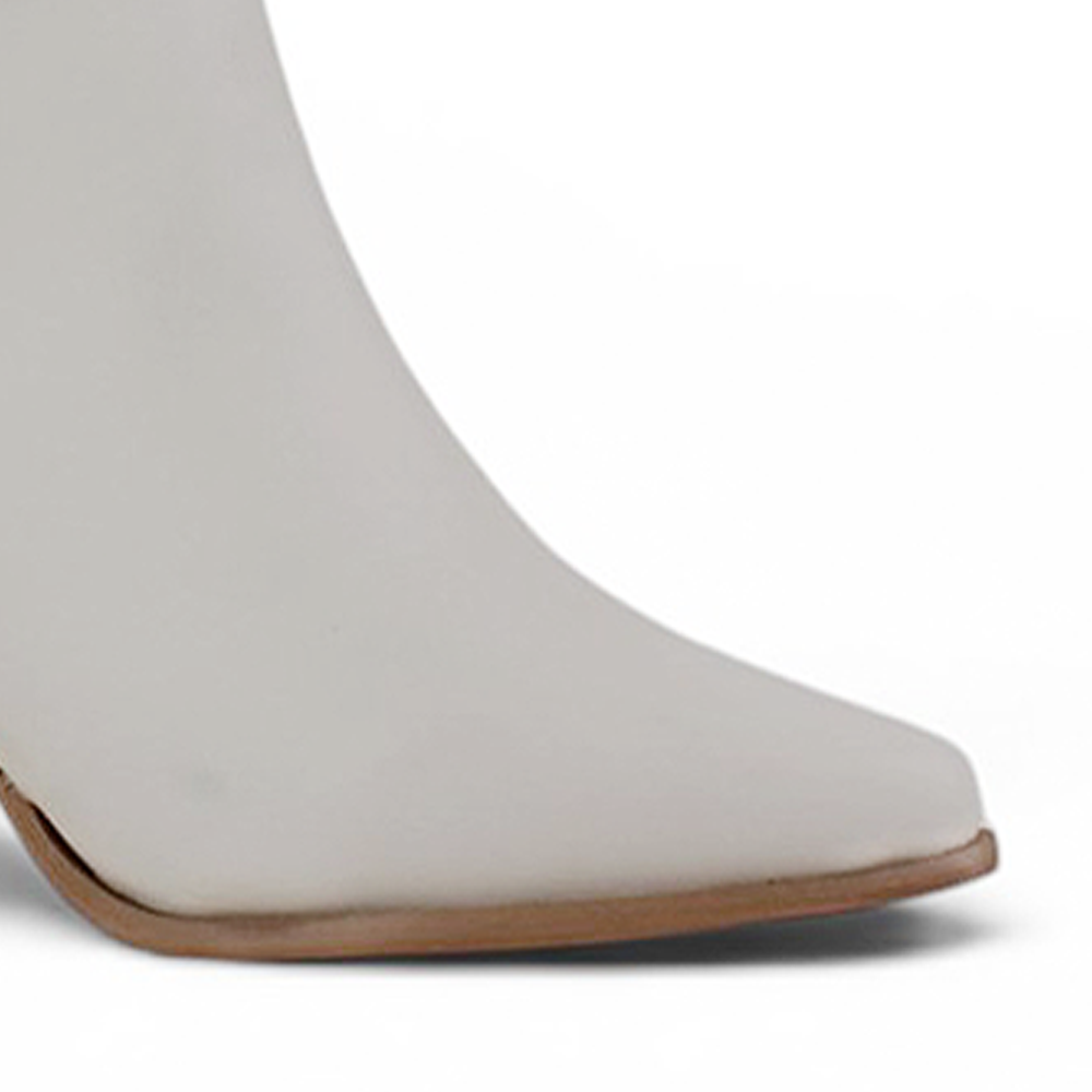 Detalle del material sintético en la bota beige con punta fina, cadena metálica y tacón medio 7 cm para dama 