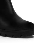 Detalle del material sintético en botín negro para dama con plataforma dentada y herraje decorativo 