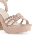 Vista a detalle de tiras cruzadas de pedrería en zapatilla nude de plataforma para mujer con tacón de 10cm y pulsera ajustable