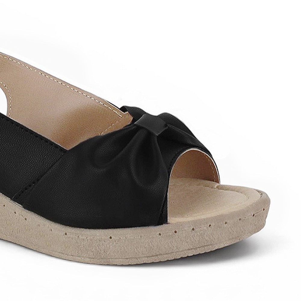 Detalle del material sintético en sandalia negra para dama con pulsera ajustable, plataforma media 5cm y punta abierta