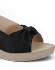 Detalle del material sintético en sandalia negra para dama con pulsera ajustable, plataforma media 5cm y punta abierta