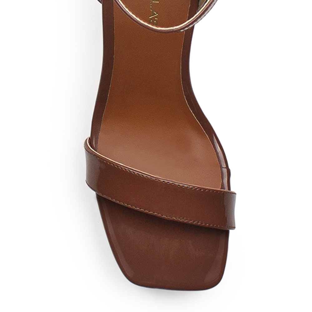 Vista de material charol en zapatilla café para mujer con punta cuadrada, pulsera al tobillo y tacón de 10cm