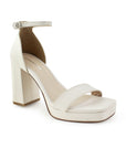 Vista diagonal de zapatilla beige para mujer con punta cuadrada ajustable con pulsera al tobillo y tacón de 10cm 