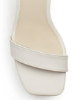 Vista de material cabra sintético en zapatilla beige para mujer con punta cuadrada, pulsera al tobillo y tacón de 10cm