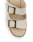 Vista de material sintético en zapatilla beige para mujer con doble correa hebillas ajustables cuadradas y tacón grueso de 8cm