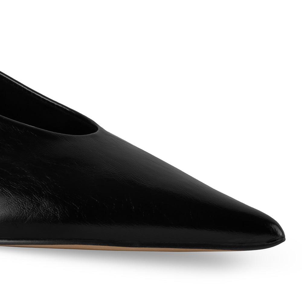 Detalle del material sintético en la zapatilla negra elegante para dama con punta fina 