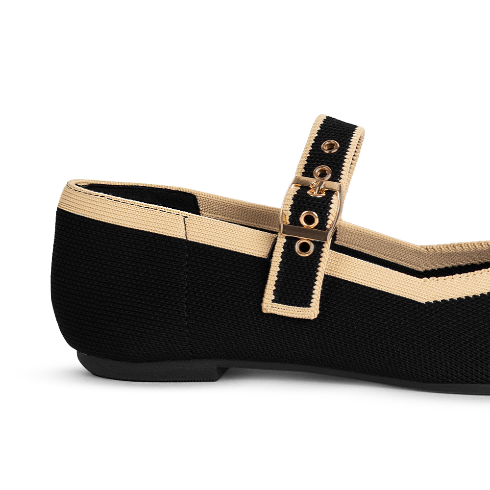 Vista trasera en la suela de piso de los flats tipo balerinas para dama color negro con bordes beige y pulsera ajustable 