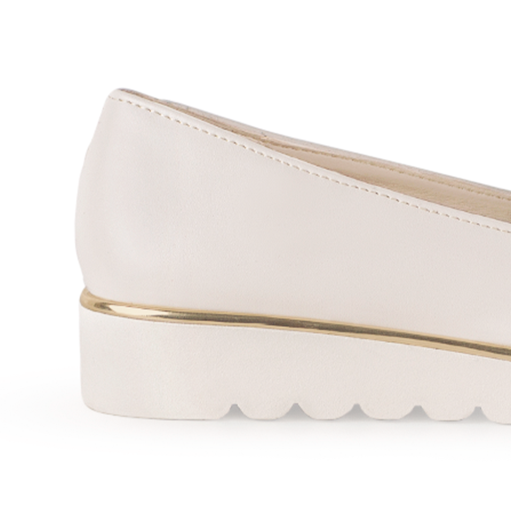 Vista del detalle metálico en la plataforma baja 3cm del mocasín beige para dama con herraje decorativo
