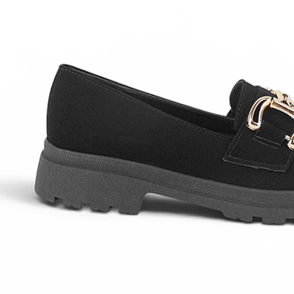 Vista trasera del tacón bajo 3cm con suela chunky tipo track del mocasín negro para dama con herraje metálico decorativo 