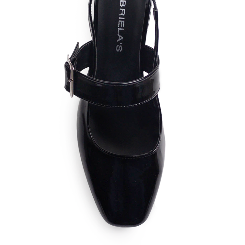 Vista de material charol en zapatilla negra para mujer con punta cerrada y hebilla ajustable