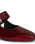 Vista a detalle de zapatilla vino para mujer con punta cerrada, hebilla ajustable y tacón bajo de 5cm