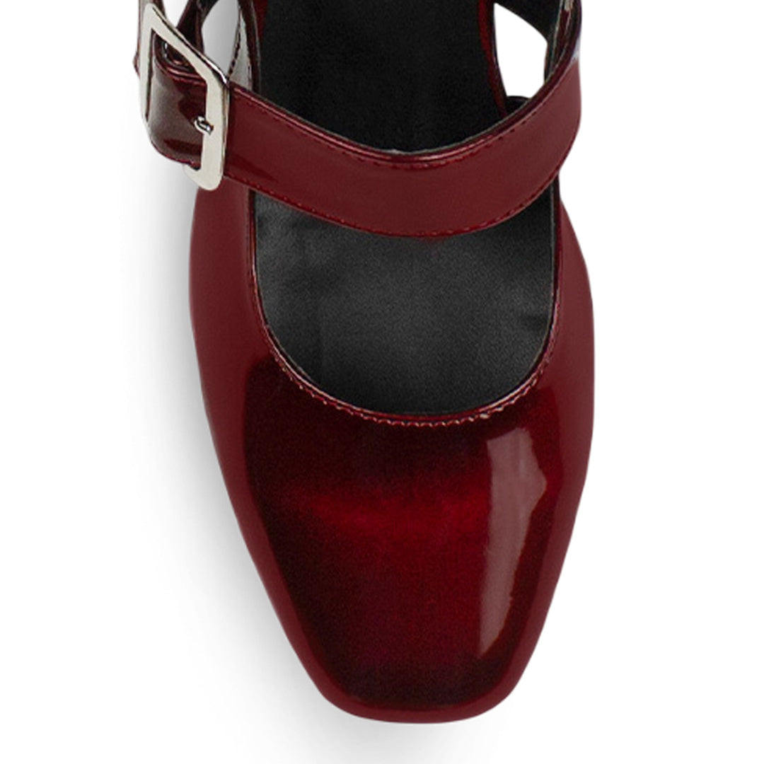 Vista de material charol en zapatilla vino para mujer con punta cerrada y hebilla ajustable