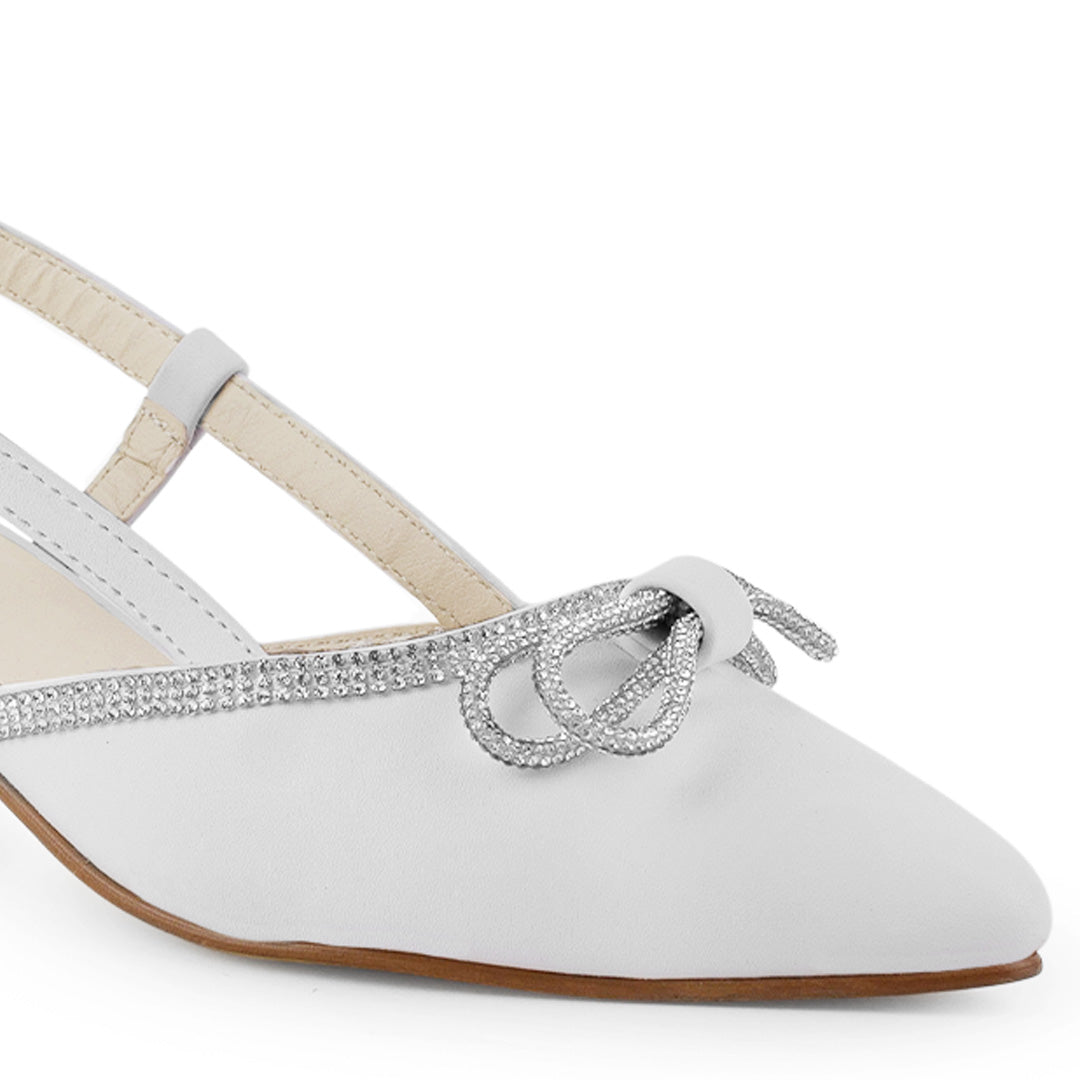 Detalle del material cabra sintético en zapatilla blanca para dama con punta fina, moño y pulsera ajustable