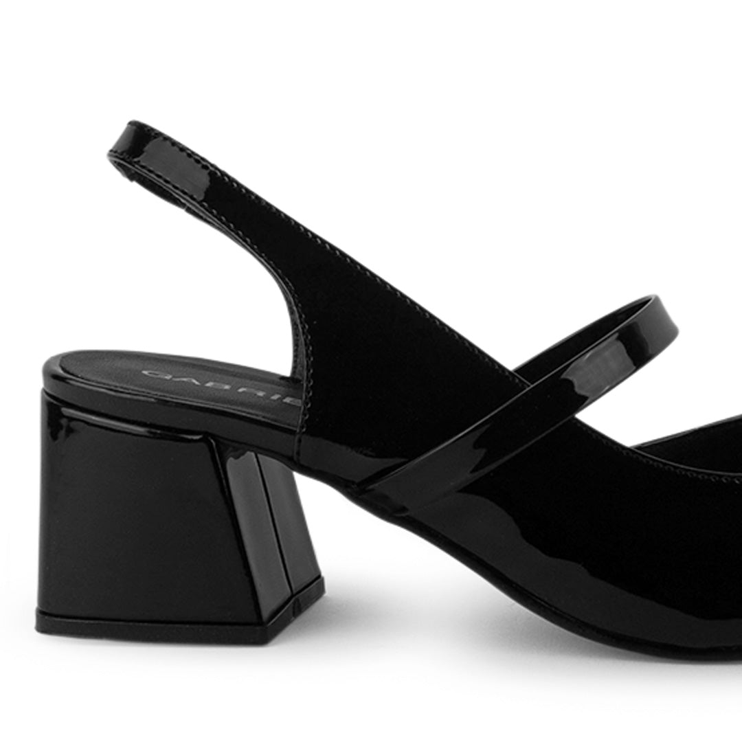 Vista trasera de tacón ancho de 6cm en zapatilla negra destalonada para mujer con moño y punta fina cerrada