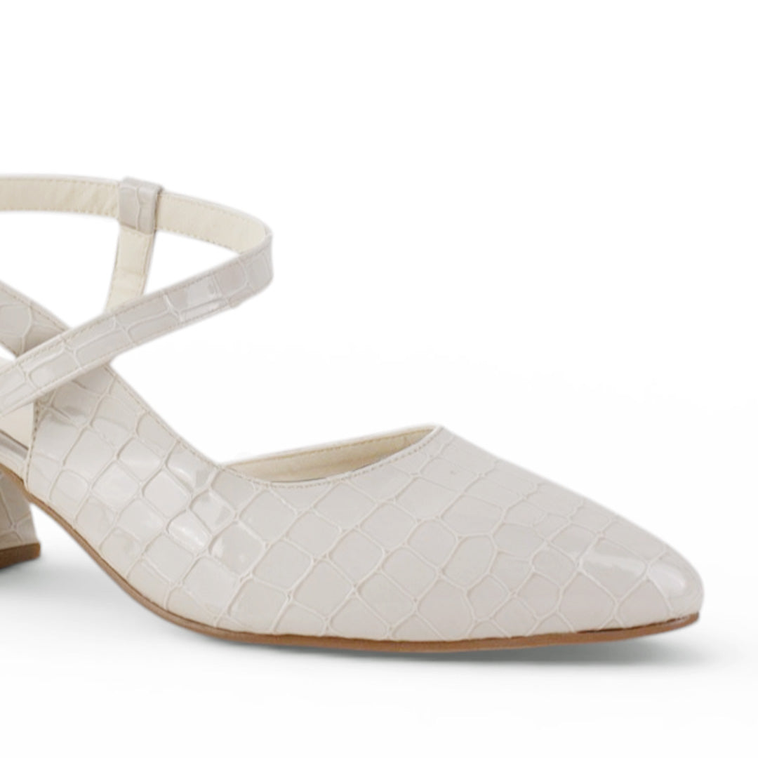 Detalle del material sintético en la zapatilla beige de punta fina con tacón bajo 6cm y pulsera ajustable 