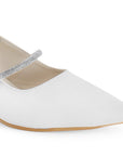 Vista a detalle de punta fina cerrada y tira de pedrería en zapatilla beige destalonada para mujer