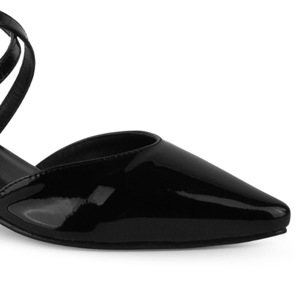 Vista a detalle de punta fina cerrada en zapatilla negra para mujer con tiras delgadas cruzadas 
