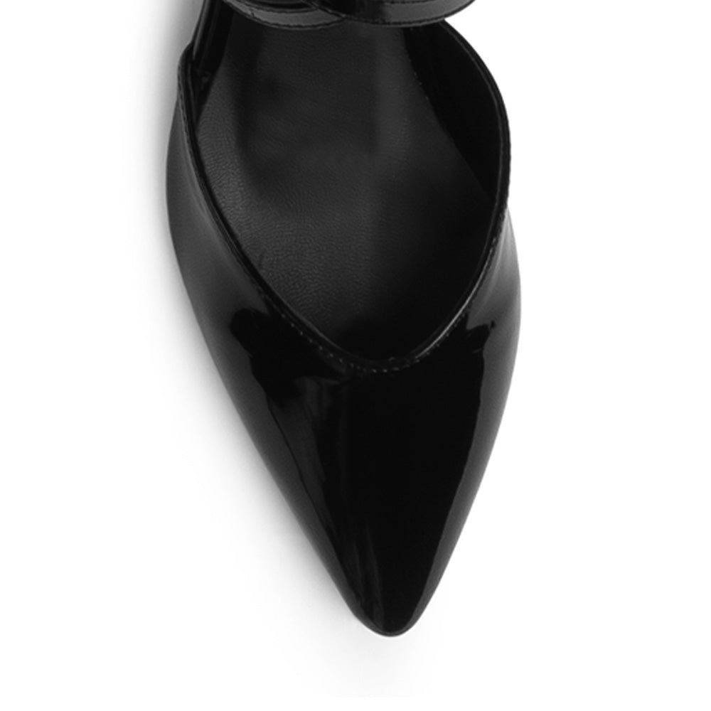 Vista de material charol en zapatilla negra para mujer con punta fina tiras cruzadas y tacón bajo de 5cm