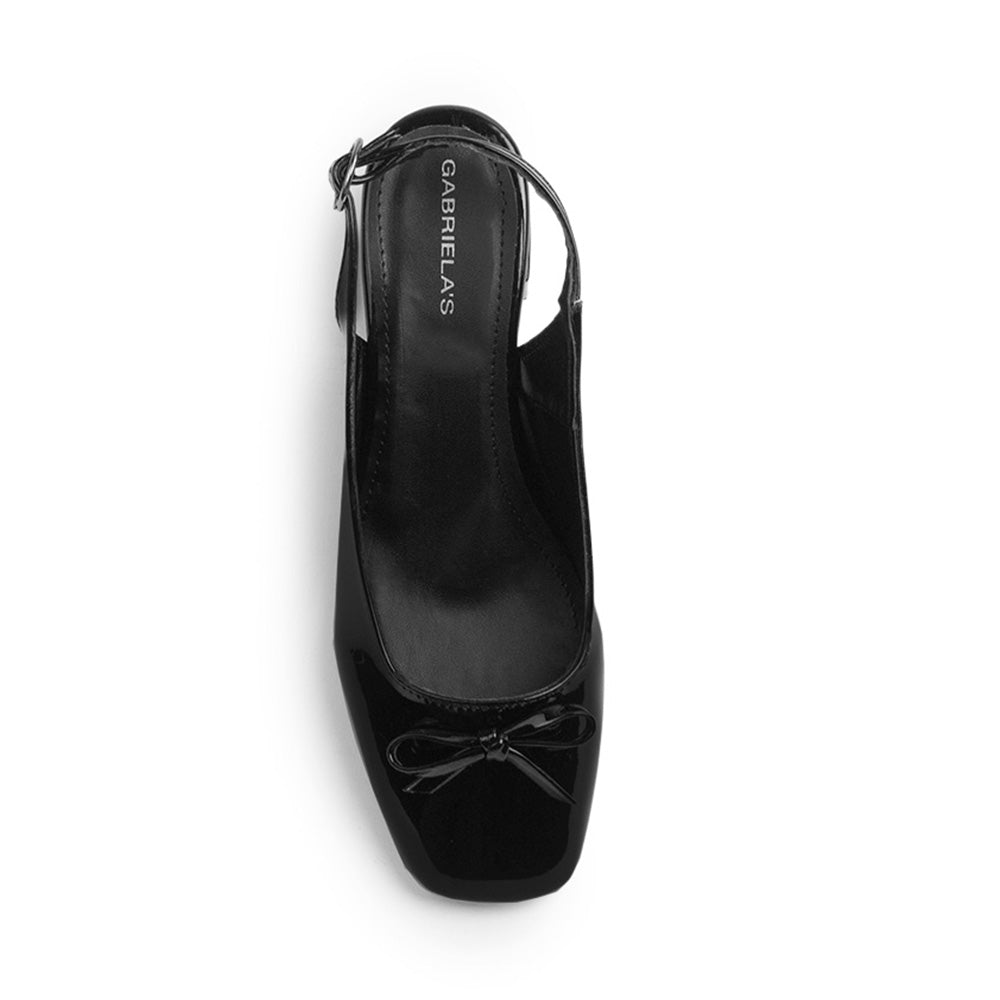 Vista superior de zapatilla negra destalonada para mujer con moño en punta cerrada 