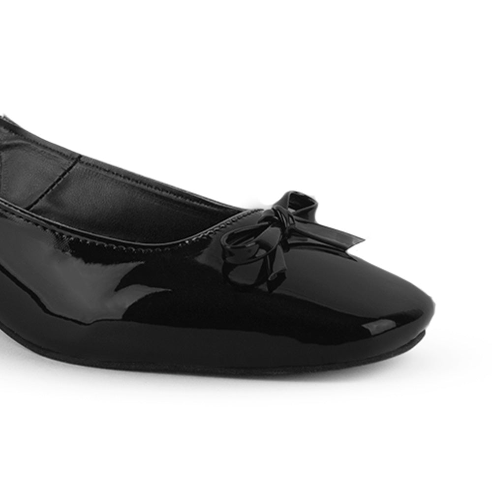 Vista a detalle de moño pequeño en punta cuadrada cerrada en zapatilla negra destalonada para mujer con tacón bajo de 5cm