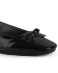 Vista a detalle de moño pequeño en punta cuadrada cerrada en zapatilla negra destalonada para mujer con tacón bajo de 5cm
