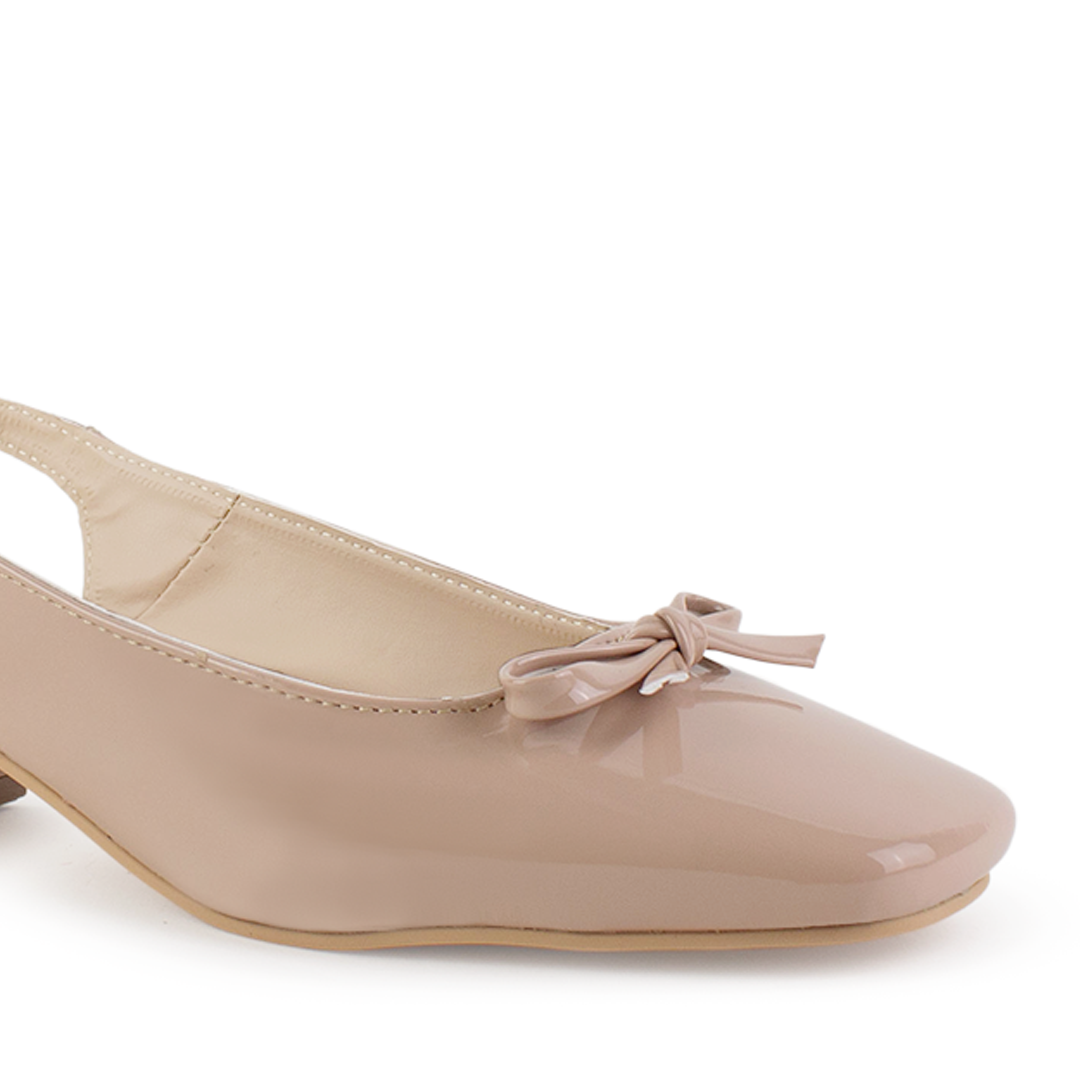 Vista a detalle de moño pequeño en punta cuadrada cerrada en zapatilla nude destalonada para mujer con tacón bajo de 5cm