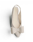Vista superior de flat beige para mujer con moño grande en punta fina y correa ajustable