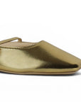 Detalle del material sintético en balerina dorada tipo mule para dama con punta semicuadrada de piso y pulsera ajustable en el empeine 