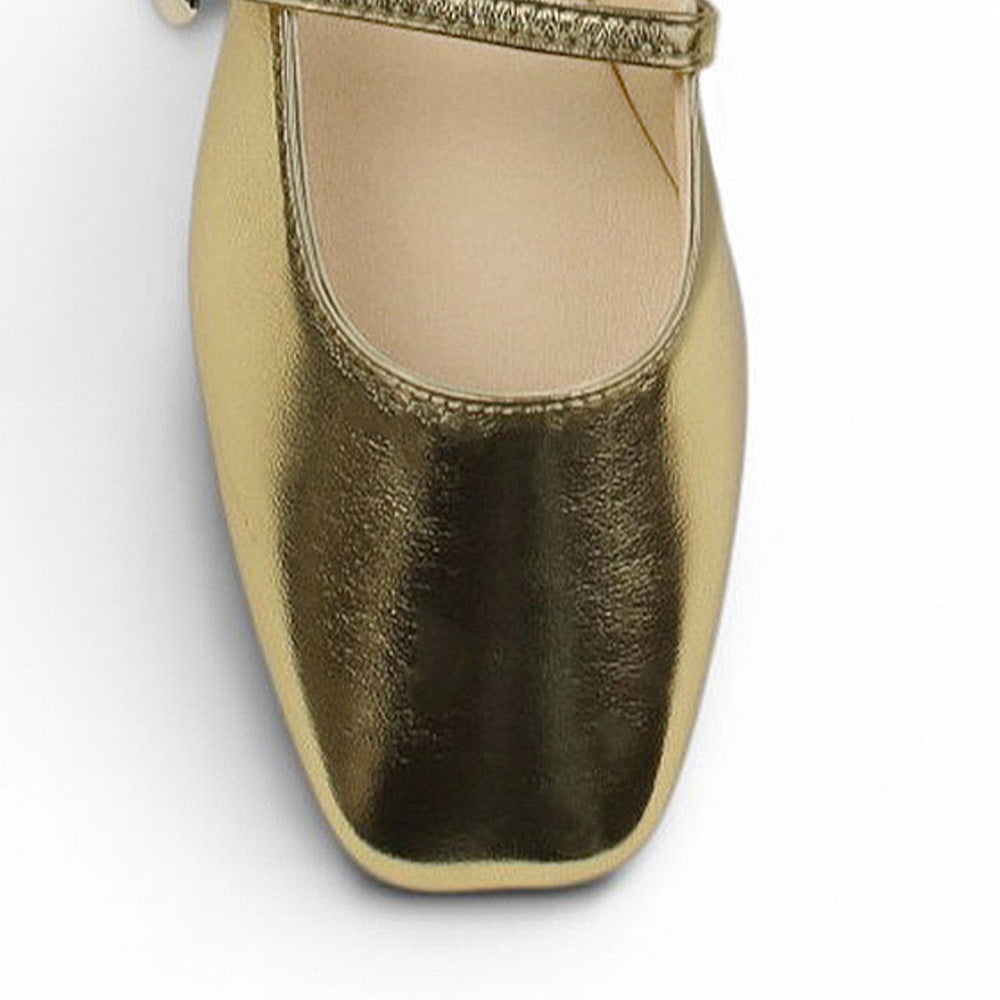Vista del detalle en punta semicuadrada de la balerina dorada tipo mule para dama con pulsera ajustable en el empeine de piso 