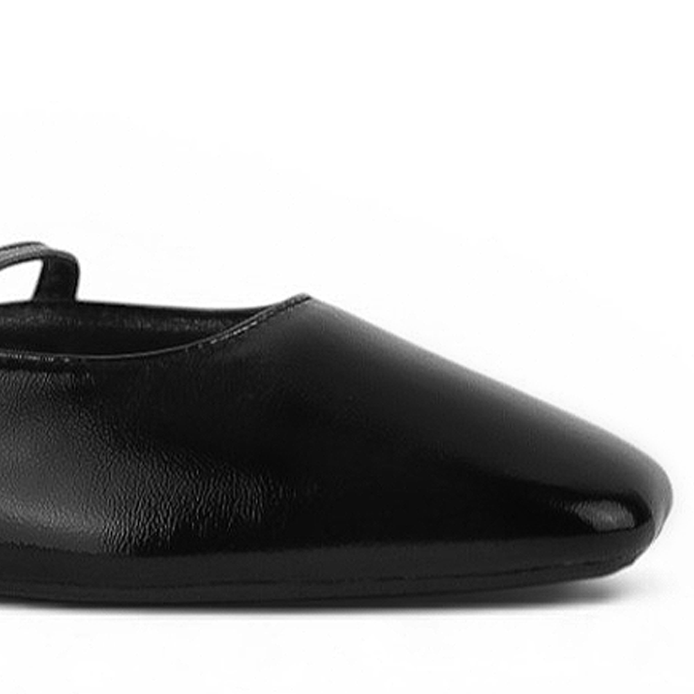 Detalle del material sintético en balerina negra tipo mule para dama con punta semicuadrada de piso y pulsera ajustable en el empeine 